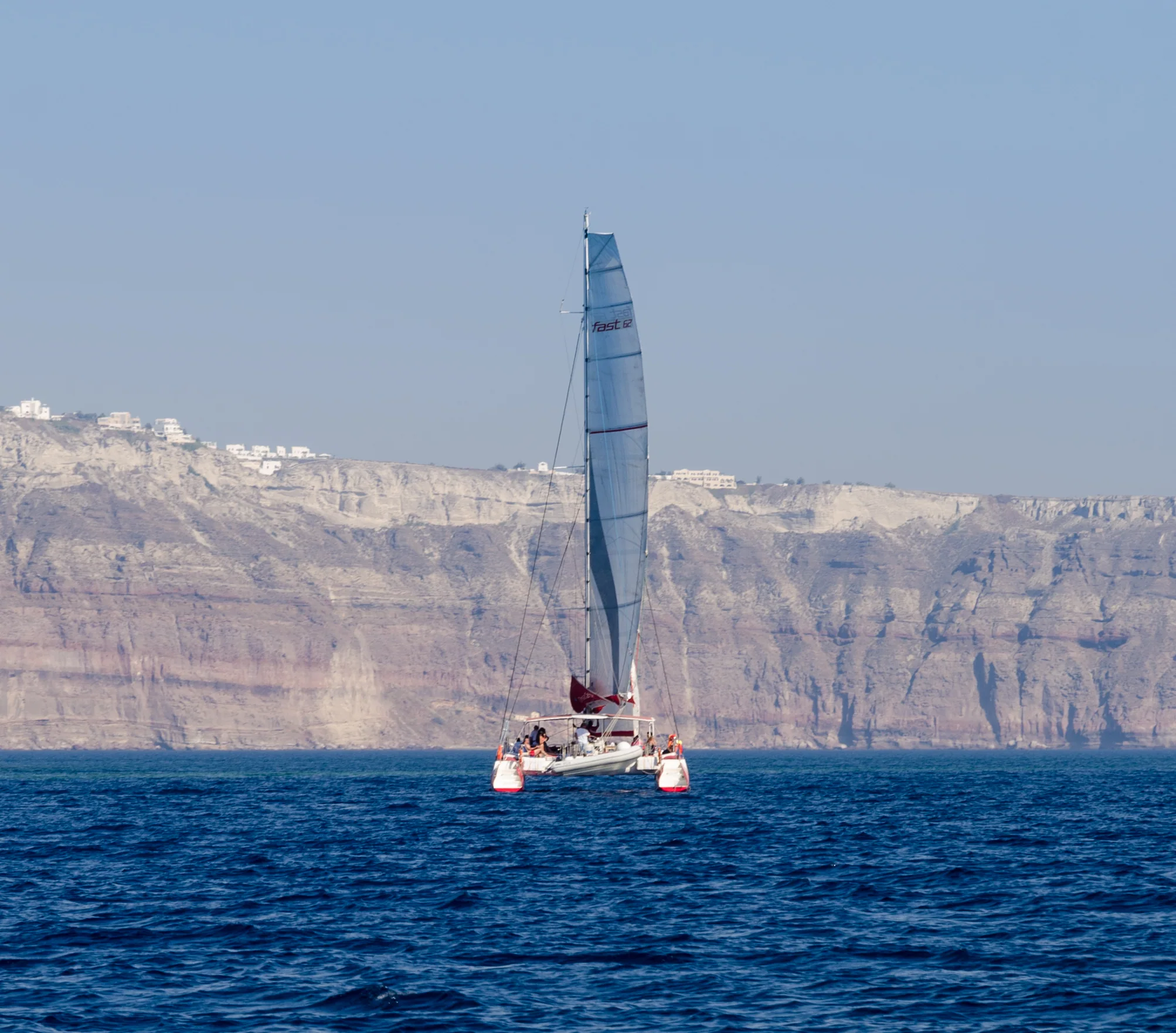 A catamaran sailing near Palea Kameni inside the Santorini caldera